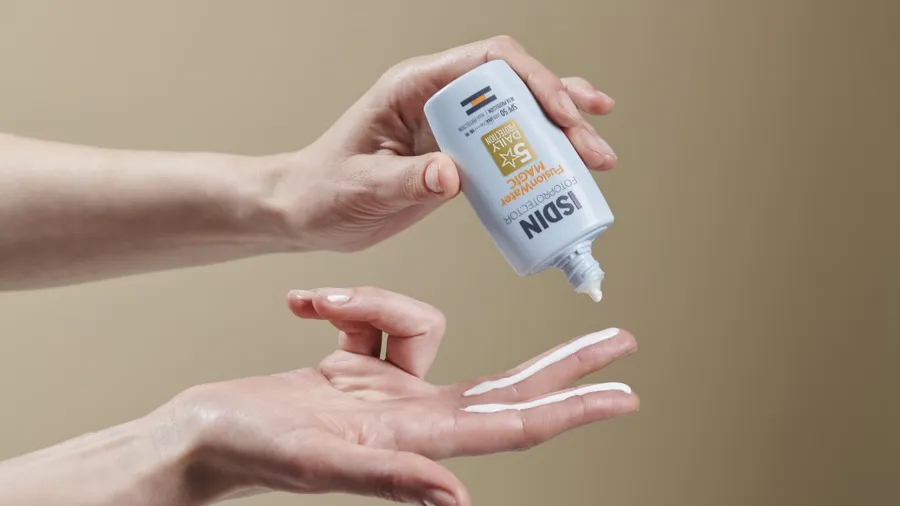 Se muestran las anos de una persona que está utilizando el bloqueador de rostro Fusion Water MAGIC Oil Control SPF 50, que te ofrece hasta 12 horas de hidratación tras un solo uso.