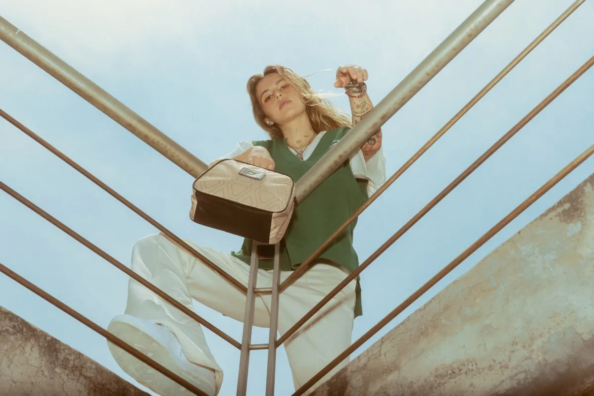 Mujer en un balcón vistiendo los puma slipstream, bolsa y chaleco
