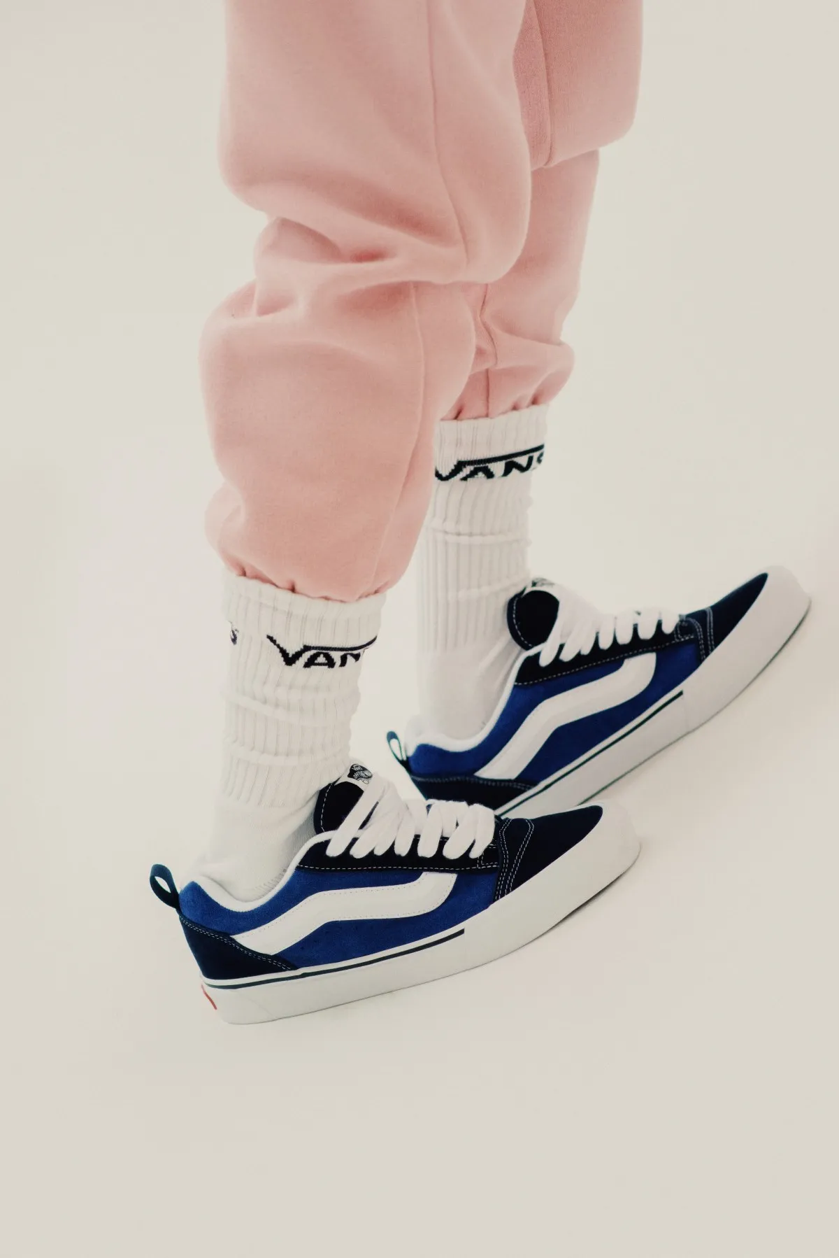 Enfoque en los pies y calcetas de Vans, luciendo los sneakers Knu Skool de Vans azules