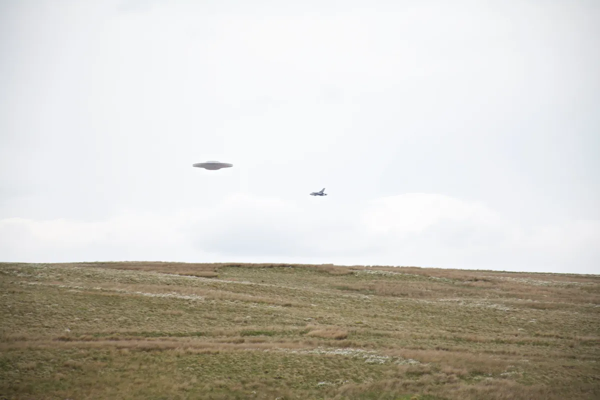 Flying,Saucer,Ufo,Over,Grassy,Moor,Escorted,By,Tornado,Jet