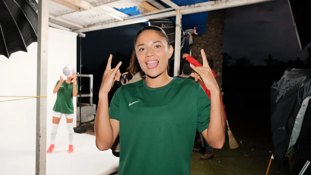 Capi Bernal muy sonriente con playera verde, durante la campaña de NIKE Piérdelo todo gánalo todo.