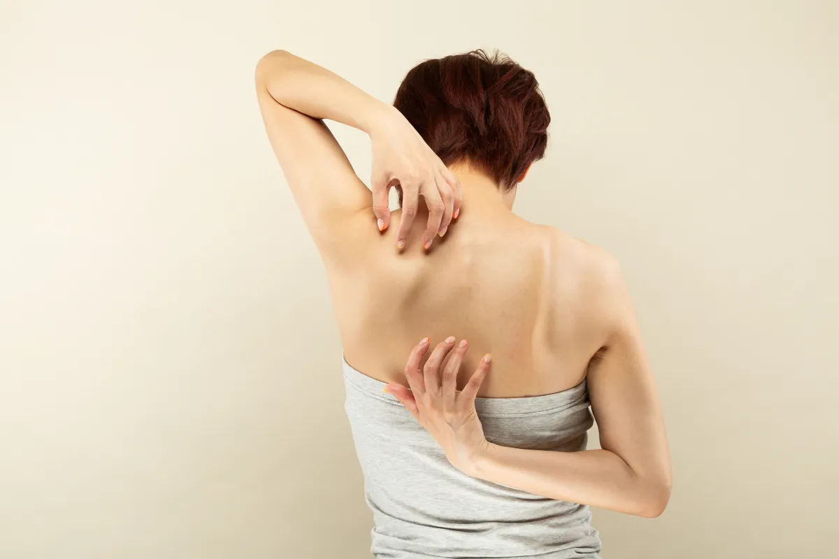 Young,Asian,Woman,Scratching,Her,Back.