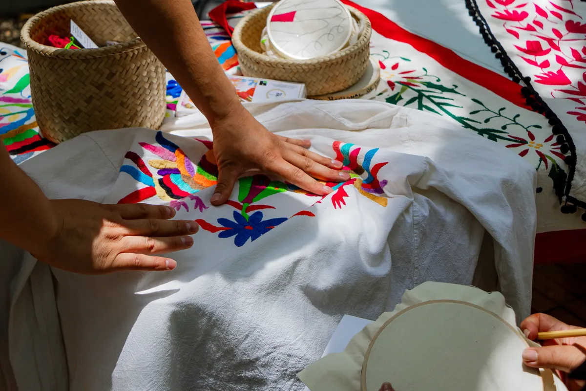 Close-up,Of,Hands,Touching,A,Colorful,Traditional,Mexican,Embroidery,With