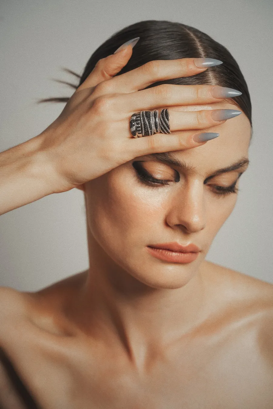 close up de mujer con una mano con cuatro anillos de bizzarro, diamante negro.