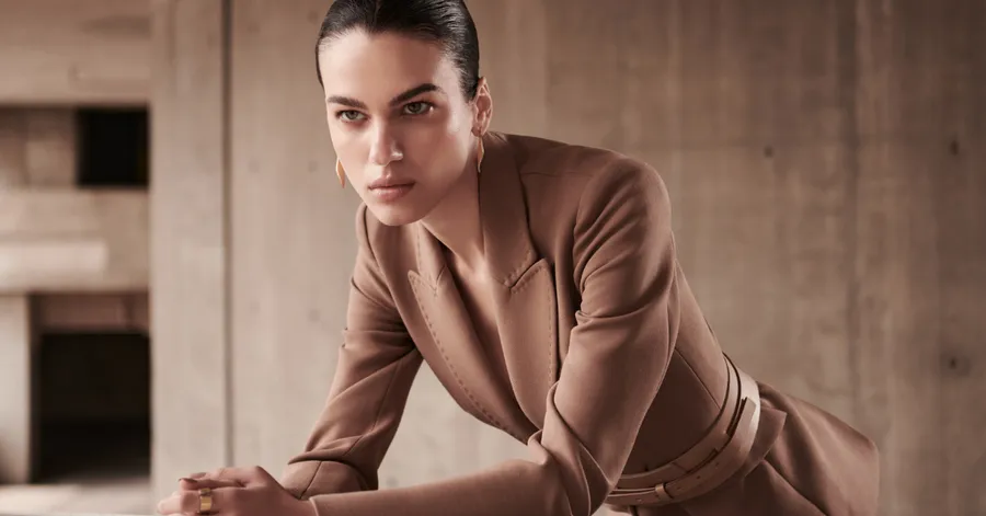 Una mujer, modelo, con un abrigo color café de la marca de El Palacio de Hierro, DHierro.