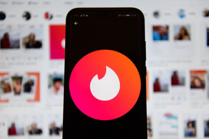 In this photo illustration a Tinder logo seen displayed on a