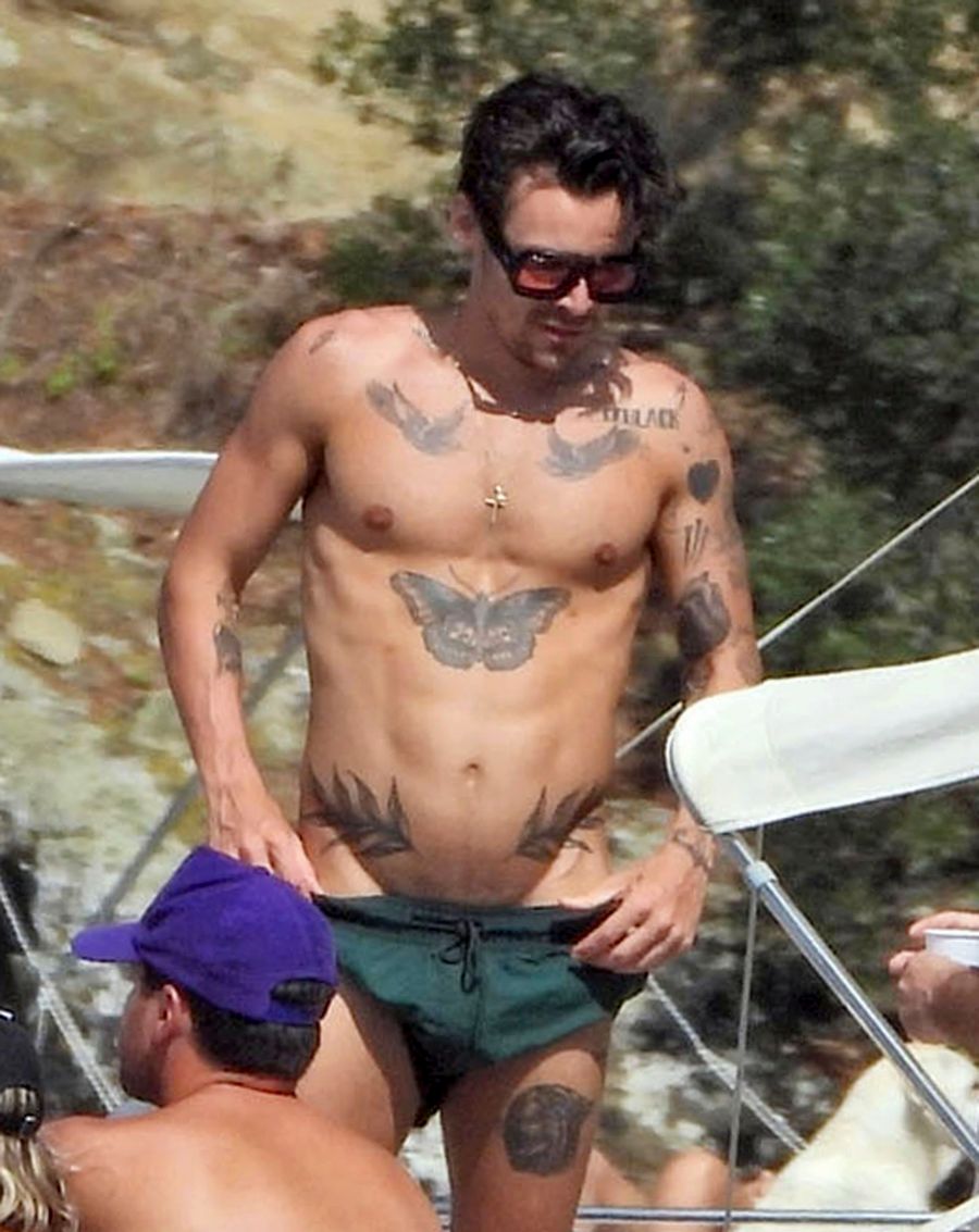 Harry Styles de vacaciones de verano usando un traje de baño verde.